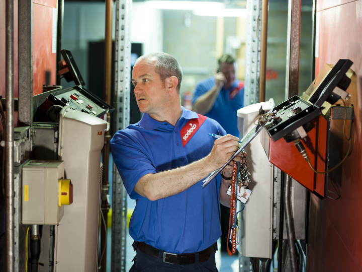 A man in a blue shirt operating a machine
