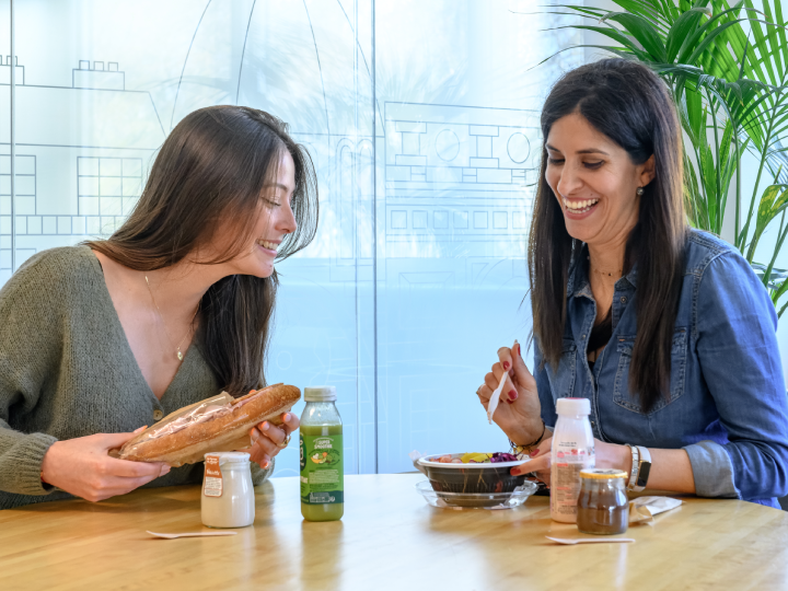 Two women enjoying a meal together at a table with food and drinks