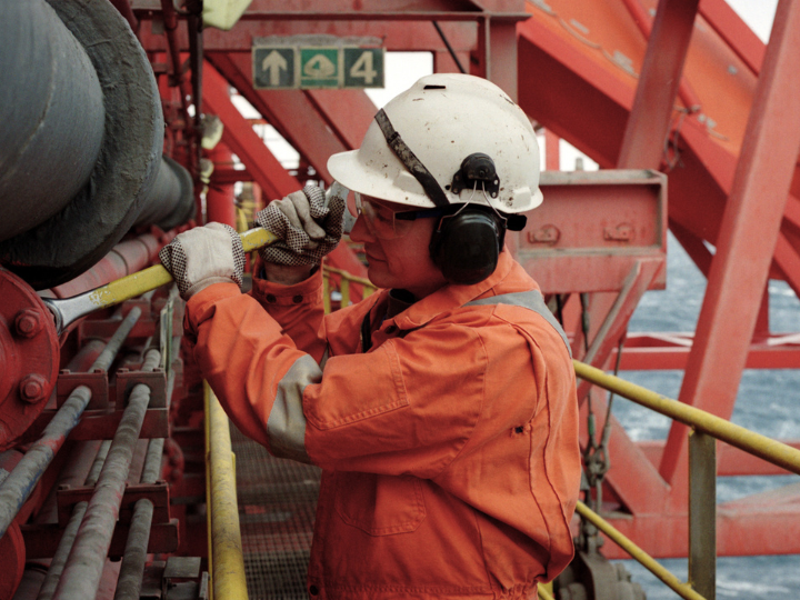 A construction worker fixing a pipe on an offshore site