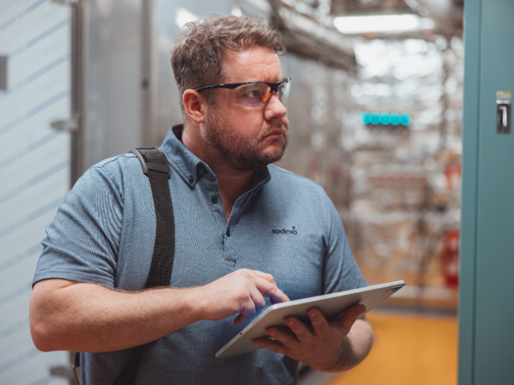 Sodexo employee checking maintenance with a digital tablet