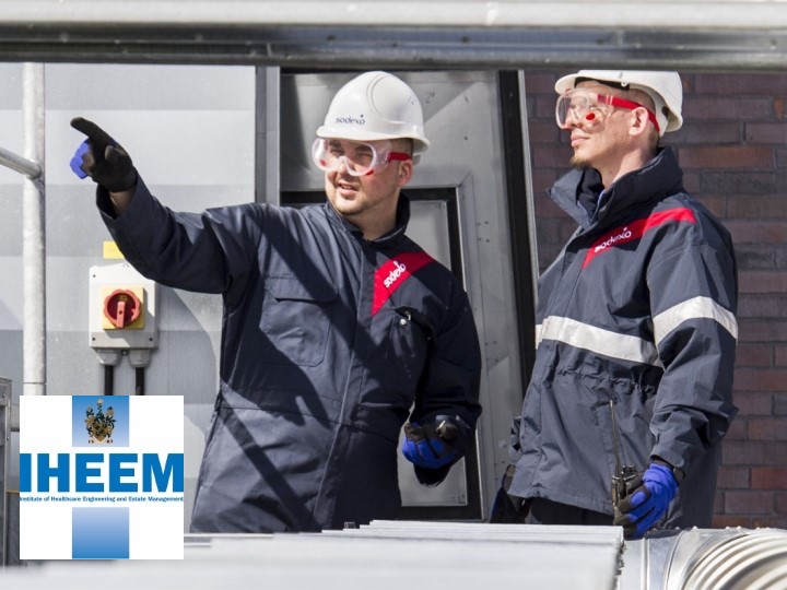 Two construction workers wearing white helmets and protective goggles