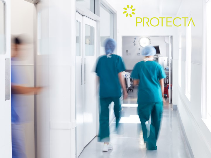 Two doctors in scrubs are walking down a hospital corridor