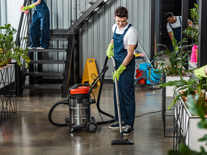 Two men in overalls and aprons diligently cleaning a room