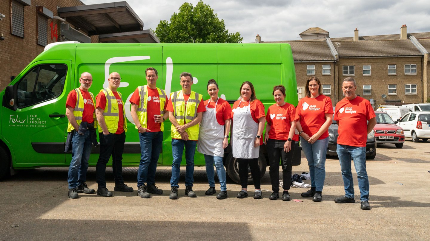Volunteers standing beside a green food distribution van
