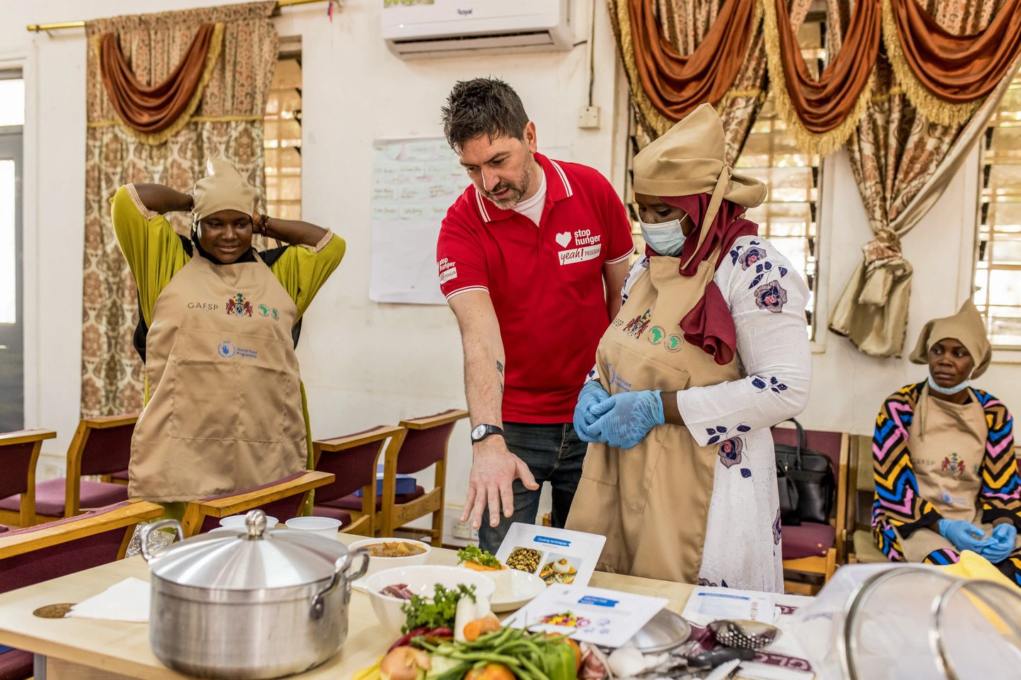 Stop Hunger volunteer preparing food with local cooks in The Gambia