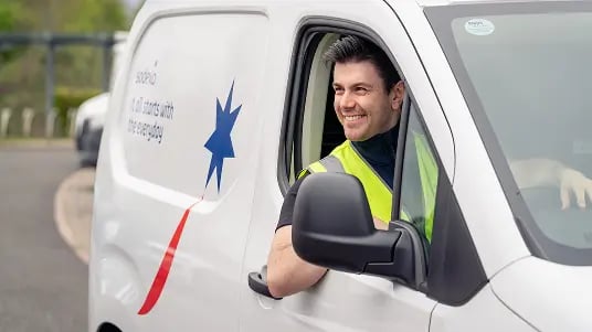 Facilities staff member in a branded service van, representing on-site property management and maintenance support.