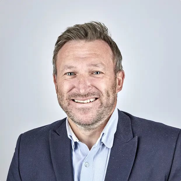 Professional headshot of a senior leader set against a neutral background, used to accompany a quote or testimonial.