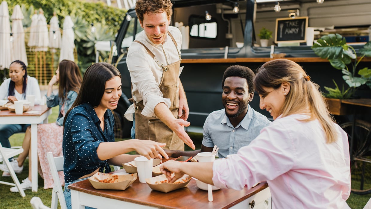 Groupe of people sitting at a table, having a meal