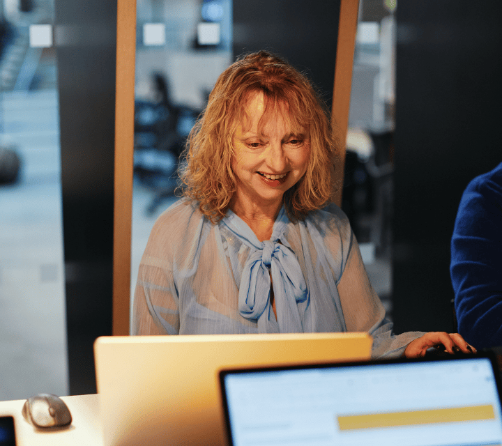 cg_smiling_looking_at_laptop_boardroom_720x640px