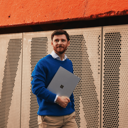 feature_card_b_Blue_holding_computer_outside_416x416px