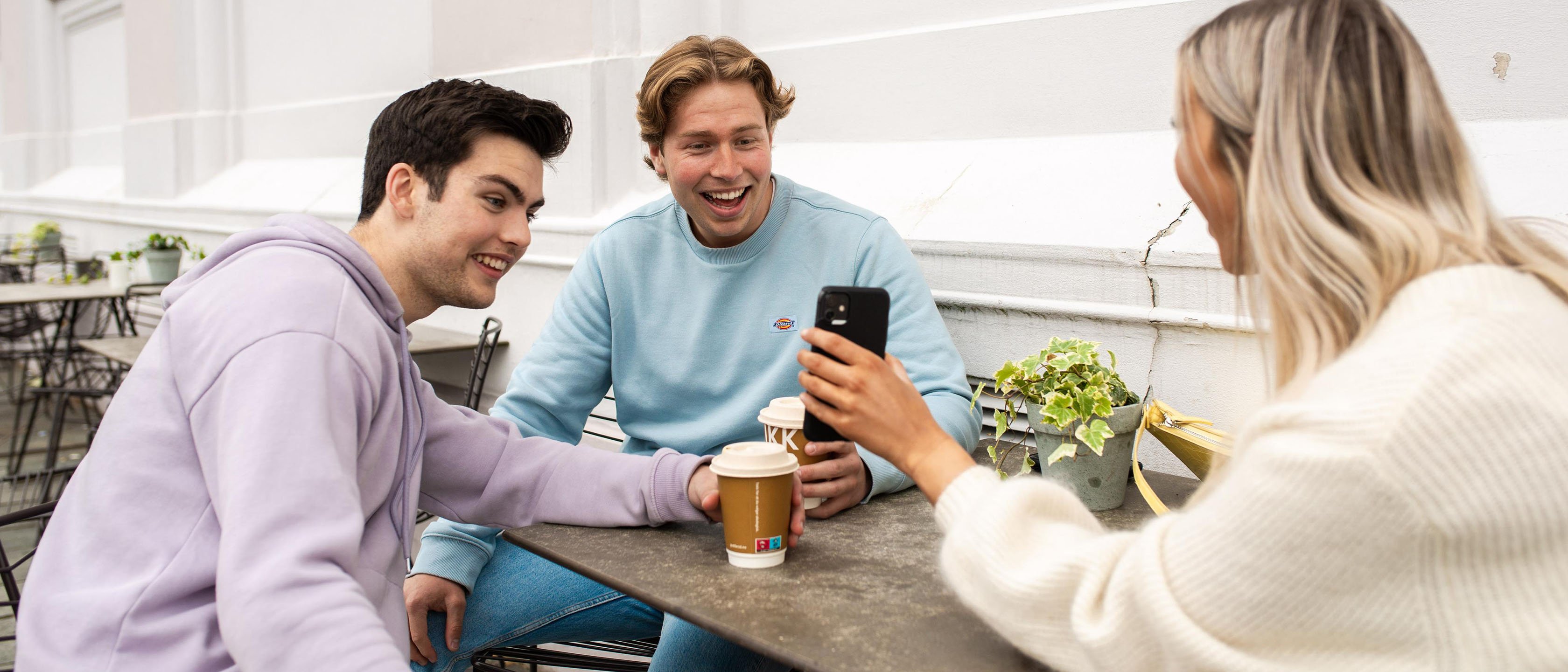 Ungdommer på kafe, ser på boliglånskalkulator på mobilen og lurer på hvor mye kan jeg låne