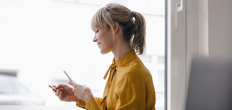 Dame med mobik og bankkort i hånden