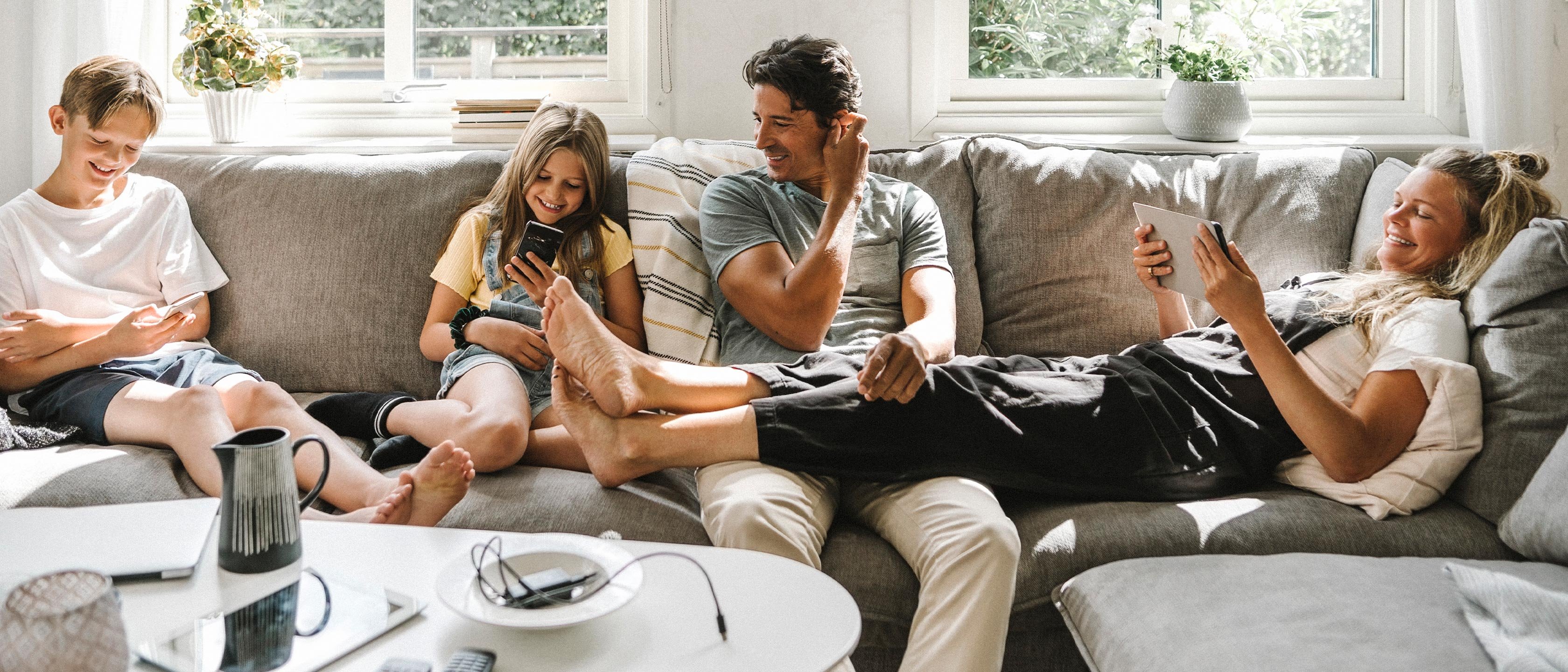 Boliglaan familie sitter i sofaen