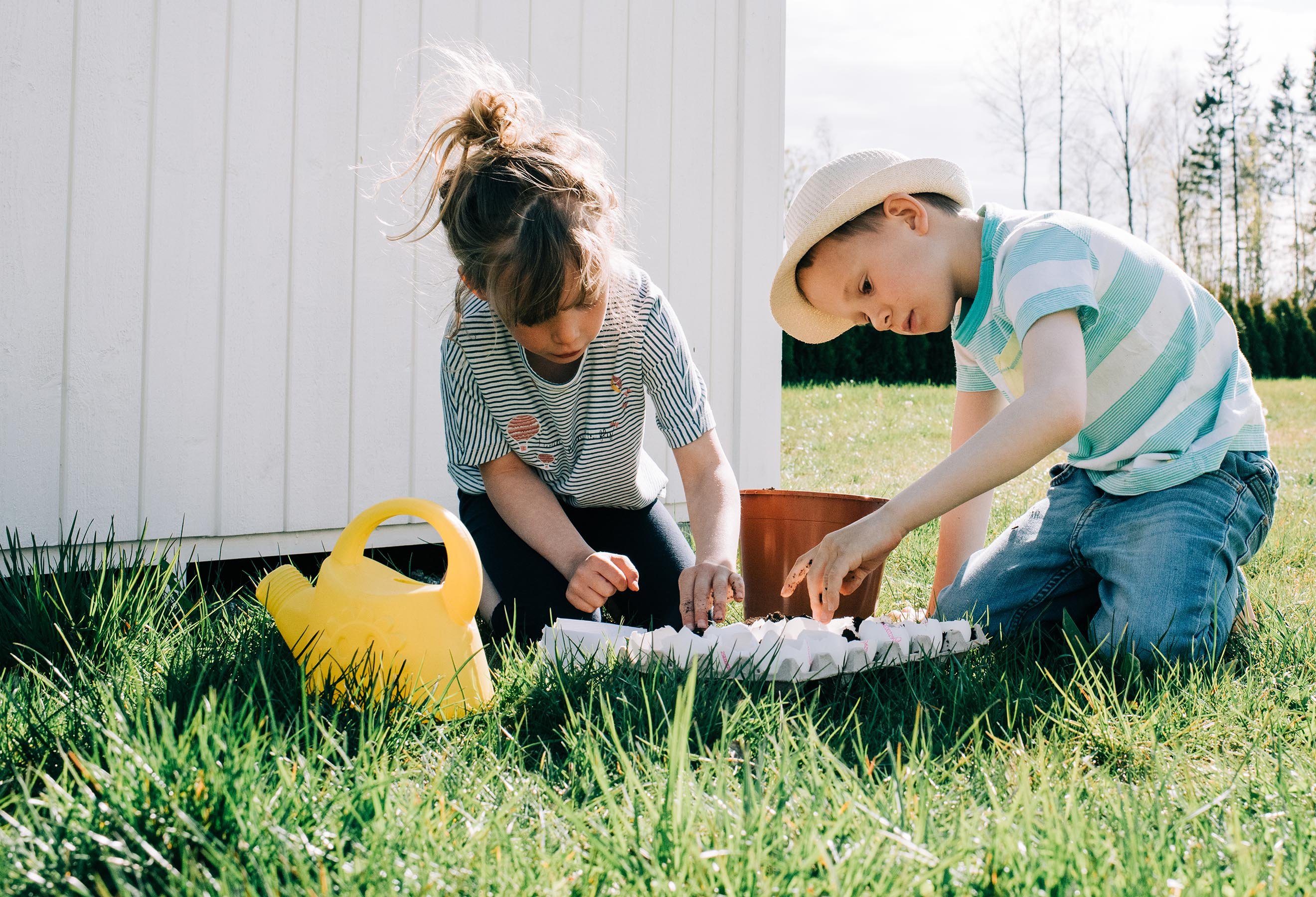 To barn leker med egg i hagen