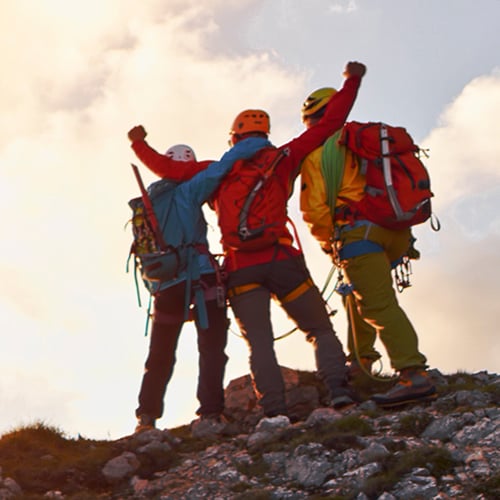 Tre klatrere på fjelltopp. Aksjesparekonto.