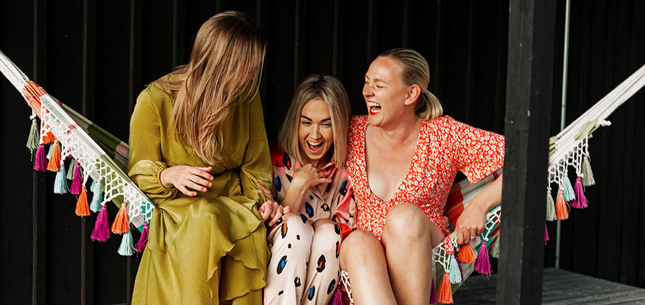 Forsikring for unge: Tre unge damer som ler i en hengekøye.  