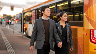 A couple exit a bus