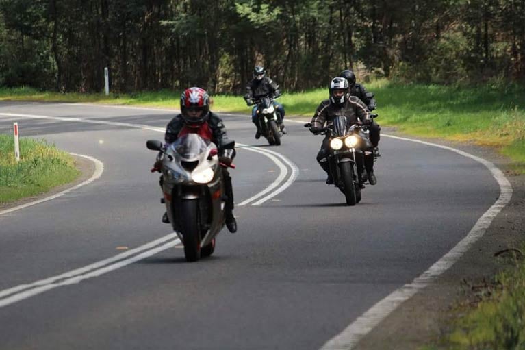 Image of three motorcyclists riding down a country road