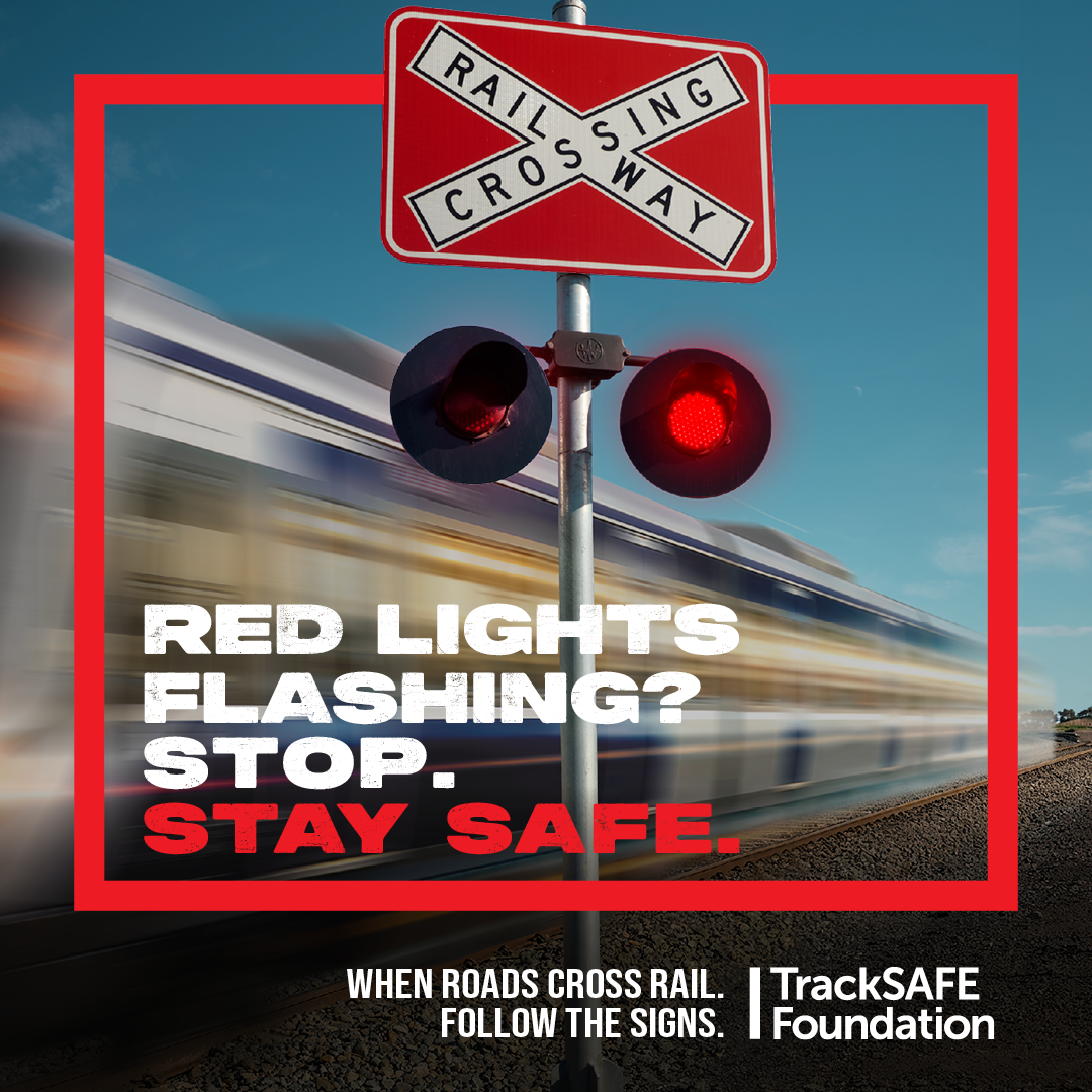 I.mage of red Lights flashing at a level crossing