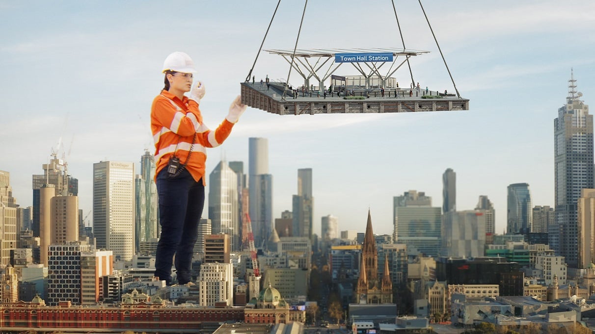 Image of a worker in high visibility clothing overseeing a crane lift