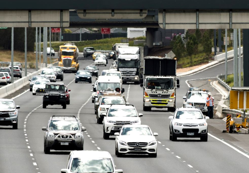 Cars and trucks driving on a metropolitan freeway