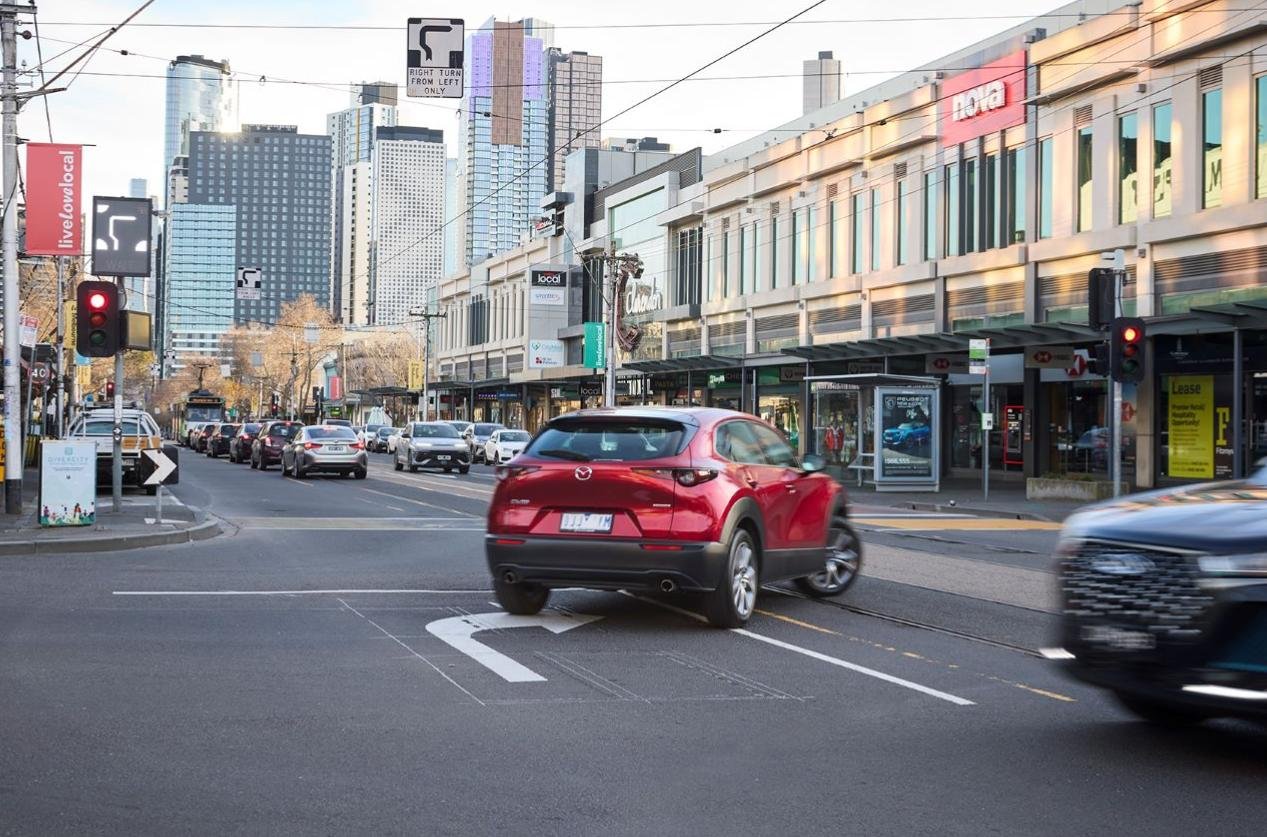 A red car doing a hook turn in South Melbourne