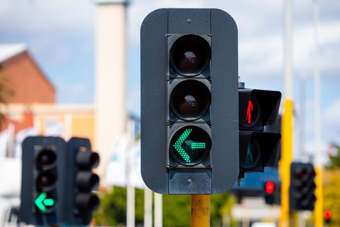 Two green turn arrows and a red pedestrian light.