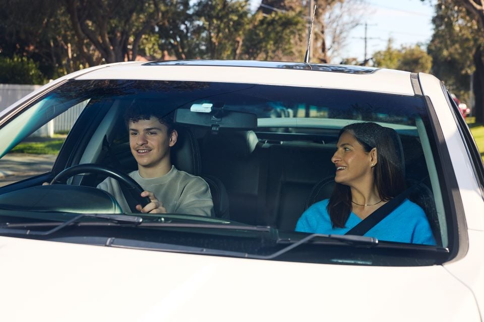 Woman putting on a seatbelt in a red car