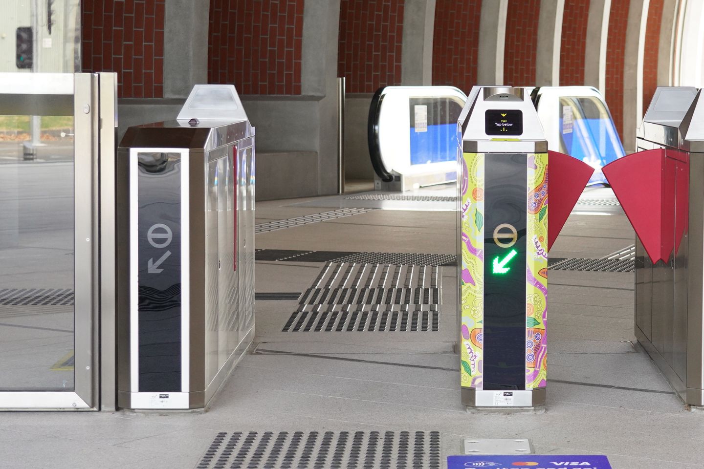 A photo of a 'wide' myki gate, large enough to allow large objects like prams and wheelchairs to pass through. The gate is open.