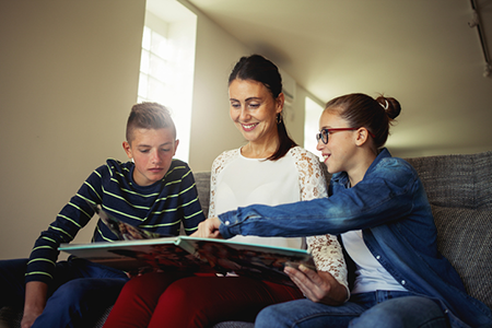 A mother and her children browse through a photo album.