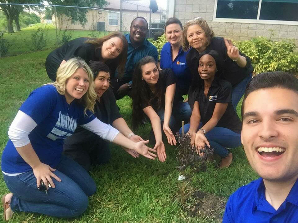 Suncoast Credit Union employees show a newly planted tree on Earth Day