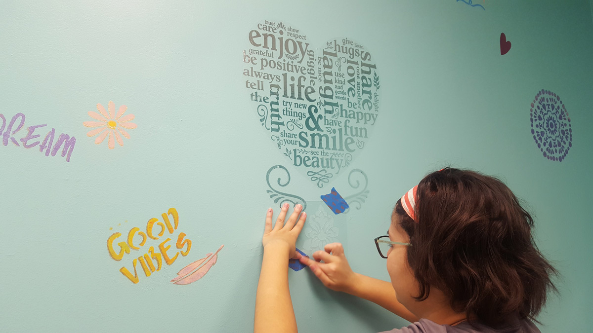 Suncoast Credit Union staff hand-paints decorations on girls bathroom at Centre for Girls