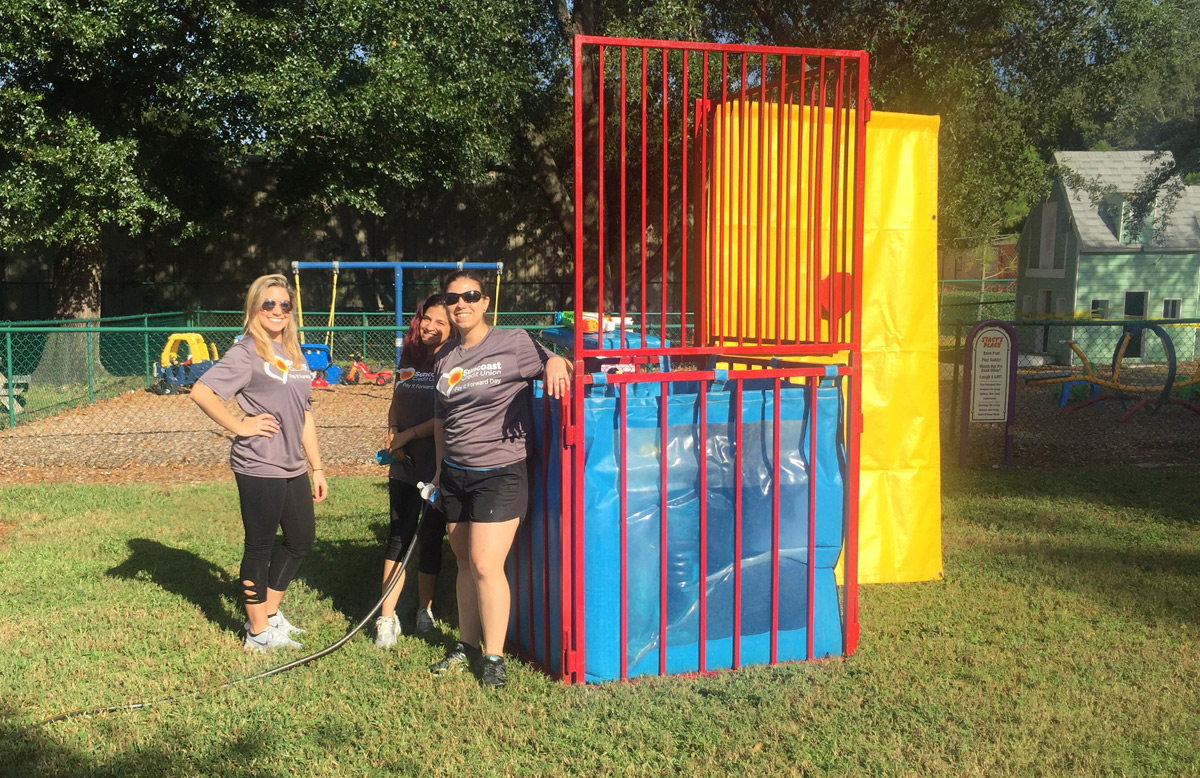 Suncoast Credit Union sets up a dunk tank while volunteering at the Kid's Place