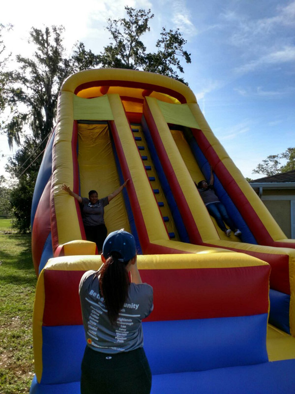 Suncoast Credit Union staff slides down on big inflatable slide at the Kid's Place