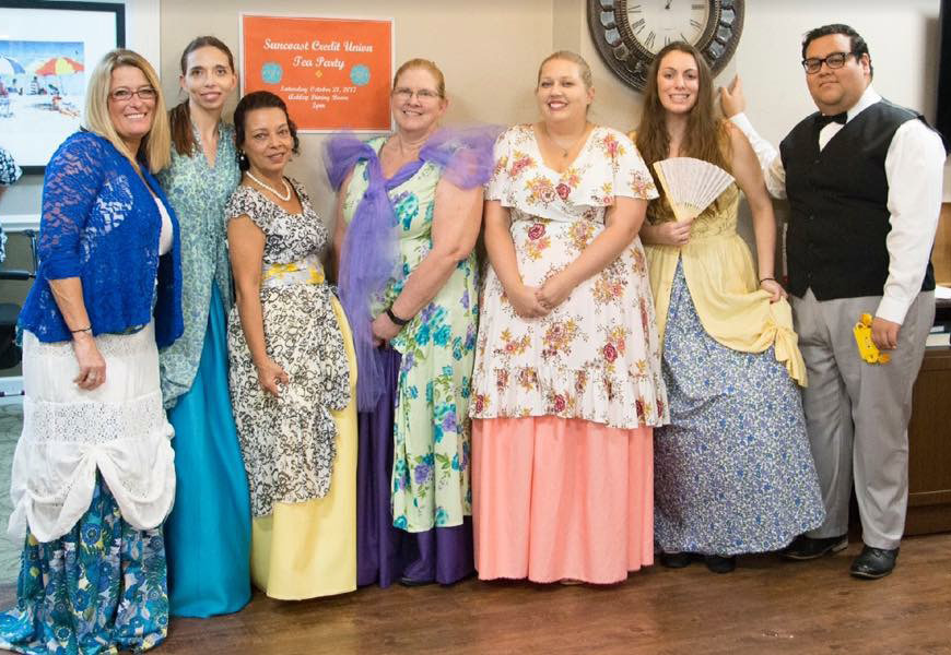 Suncoast Credit Union staff dressed up in Victorian dresses while volunteering at a Tea Party for Royal Palms Retirement Home