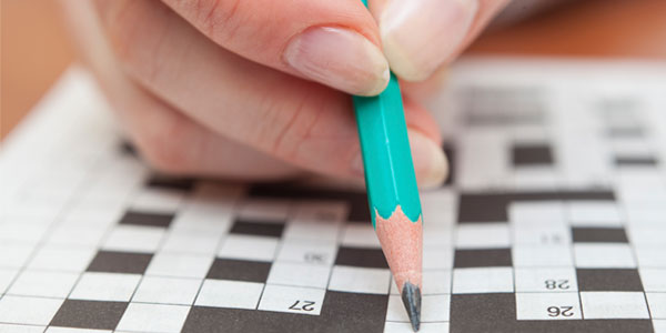 Close up of person doing crossword puzzle