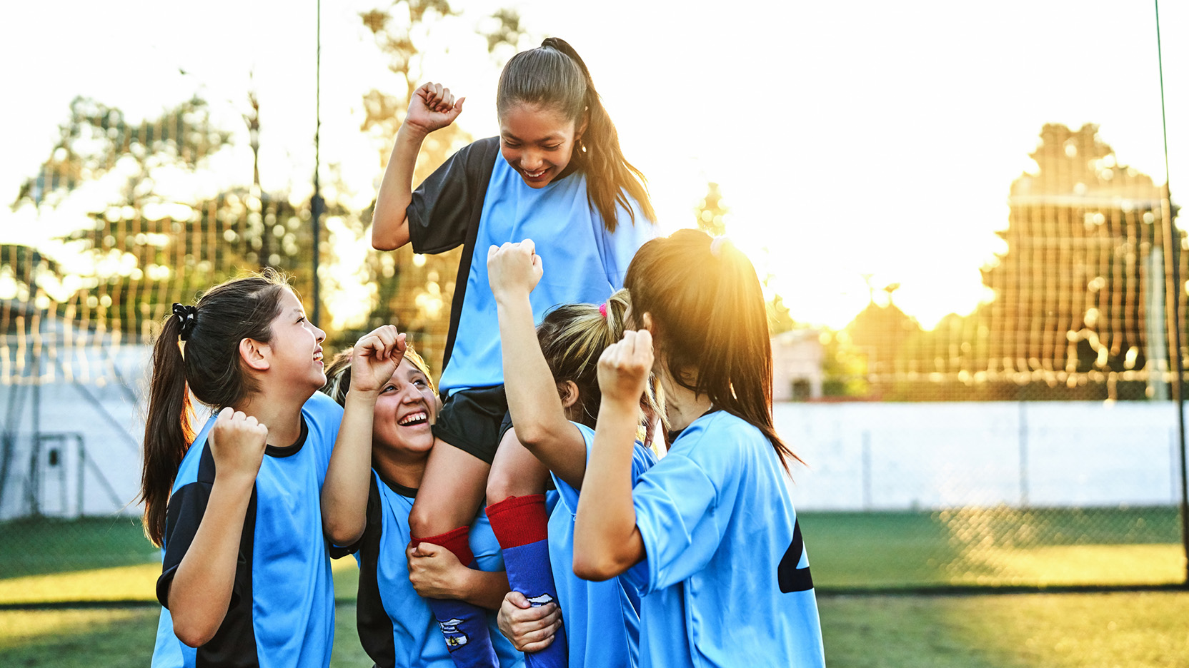 Cheerful girls soccer players celebrating success.