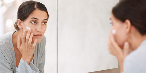 Woman applying skin cream