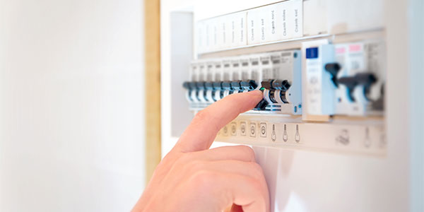 Close up of hand flipping a switch on a circuit breaker