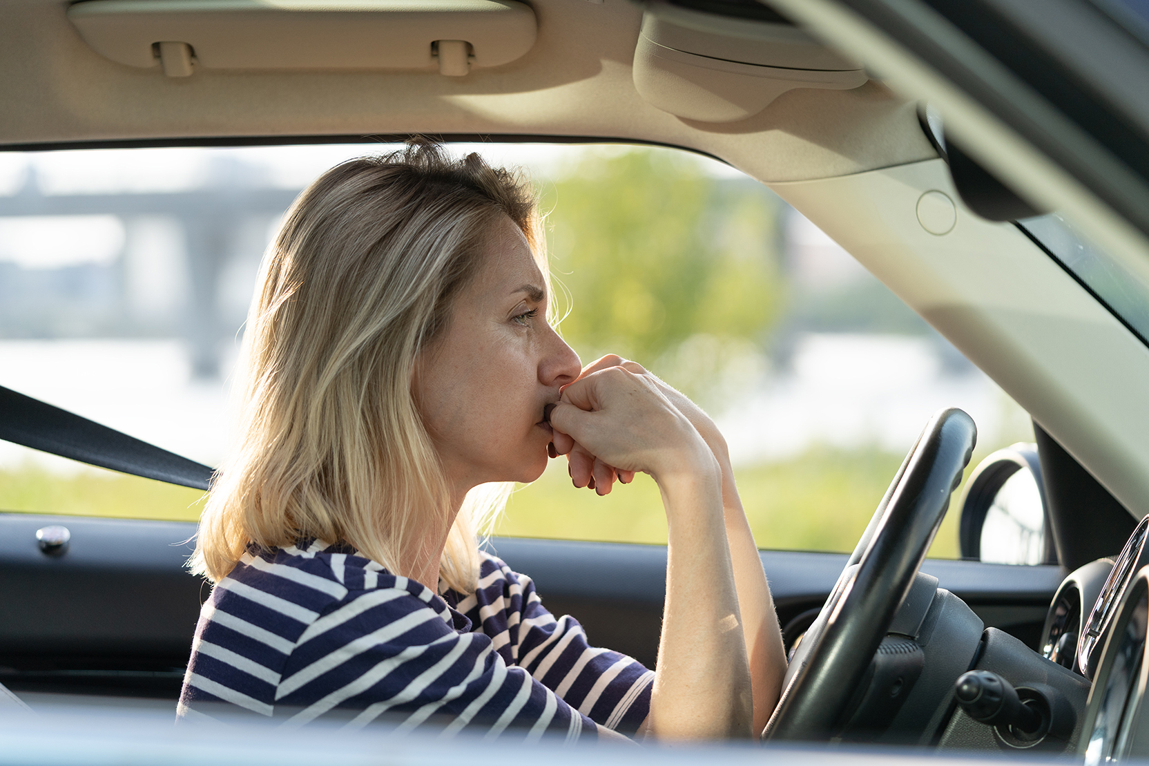 Stressed middle aged woman sitting pensively in her car