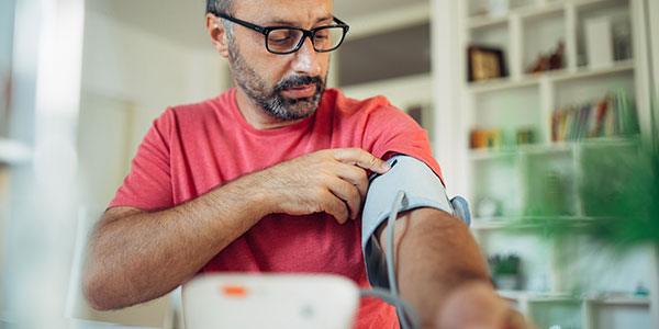Man taking blood pressure at home