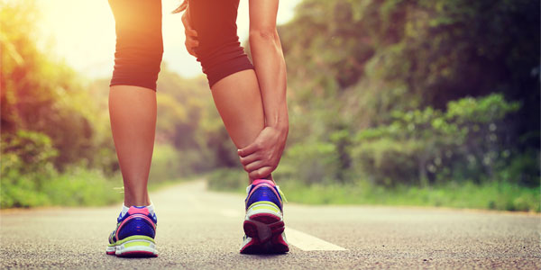Woman holding back of ankle in pain