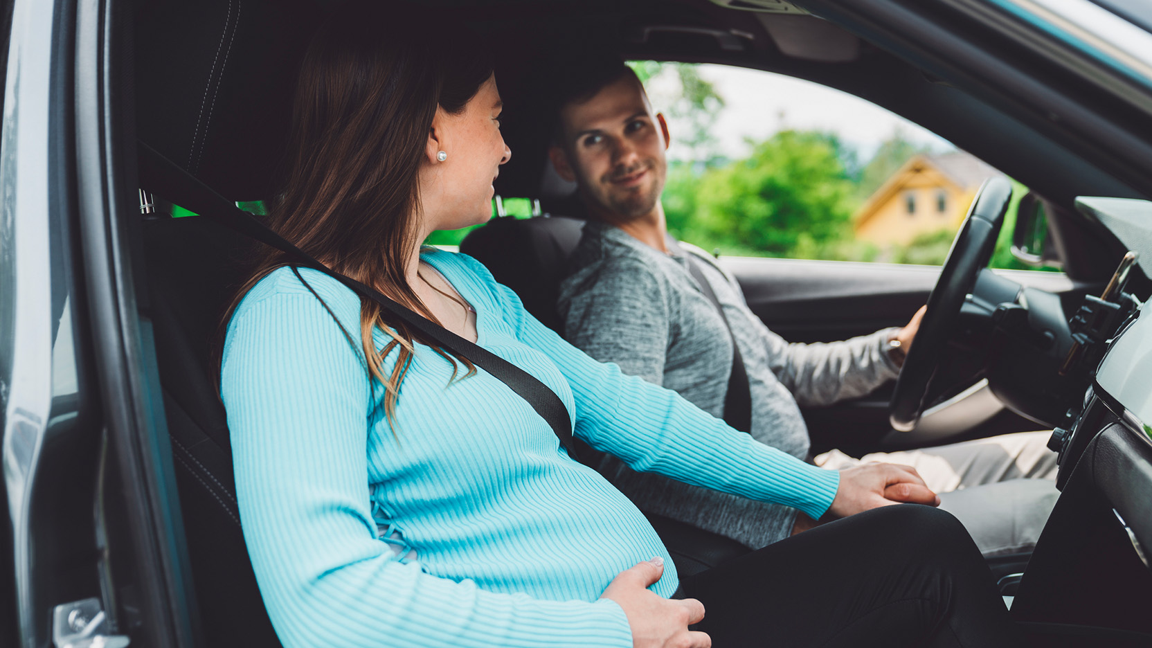 Pregnant woman and her husband sitting in the car, on their way to the hospital.