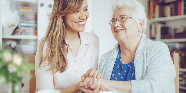 Young Hispanic woman visiting senior woman