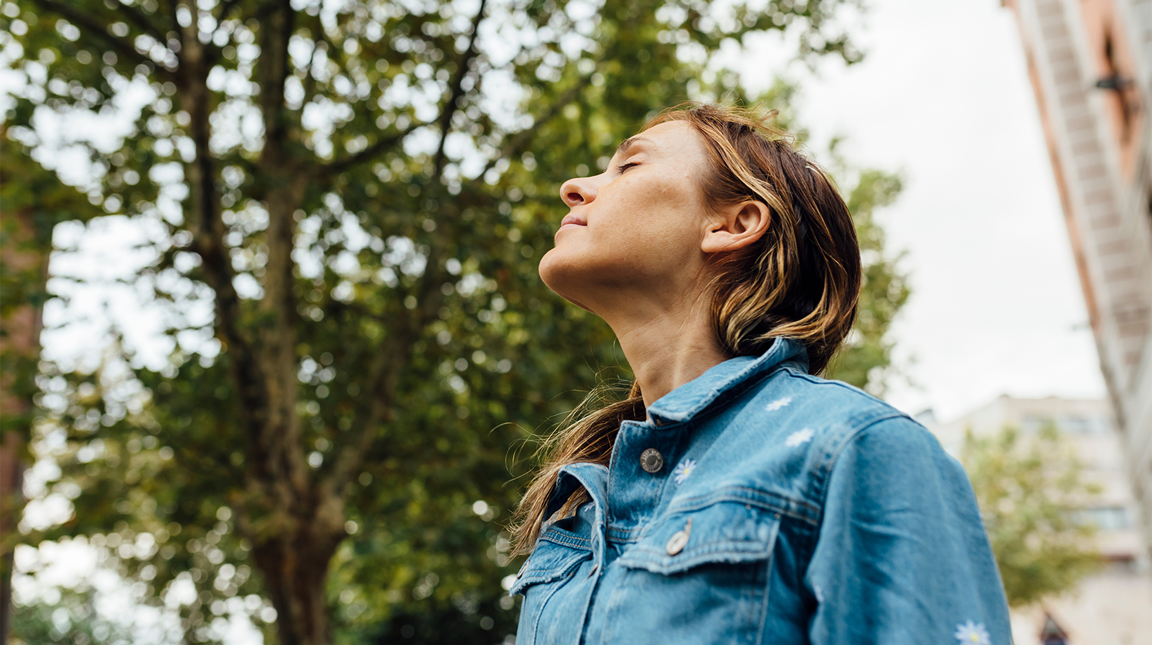 Woman with allergies breathing in while outside