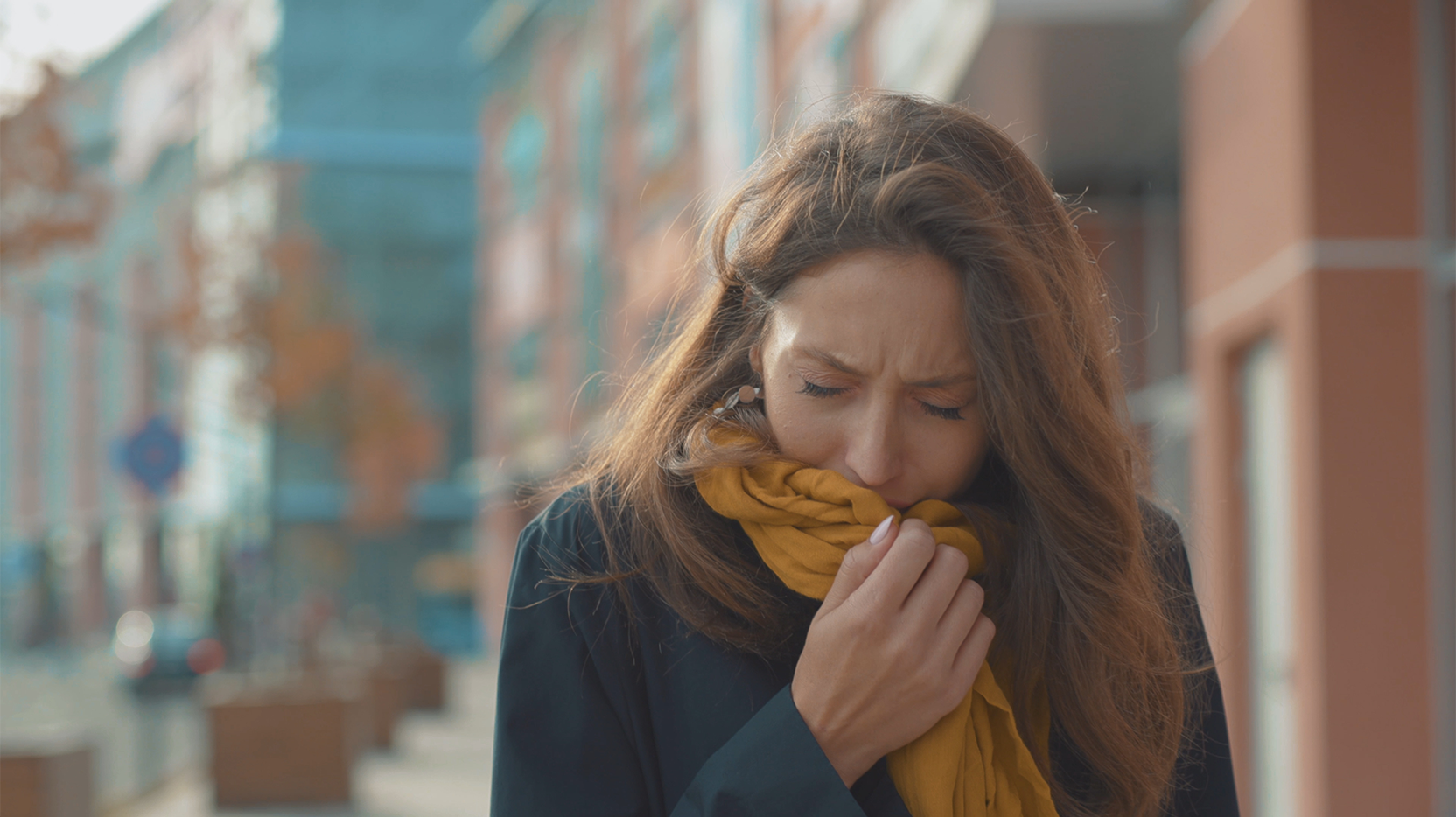 woman coughing in scarf