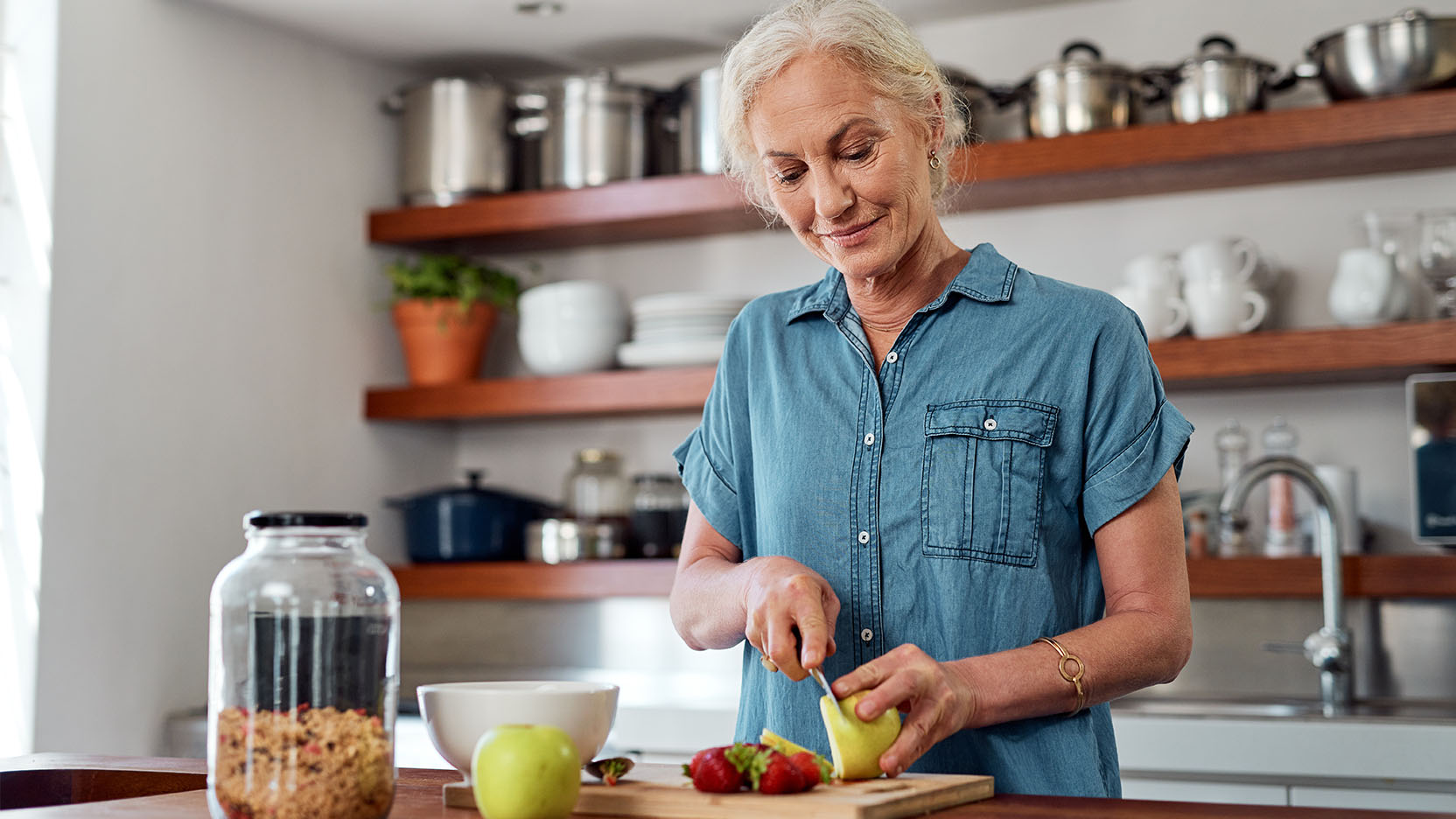 Older woman prepares a healthy meal in her kitchen 