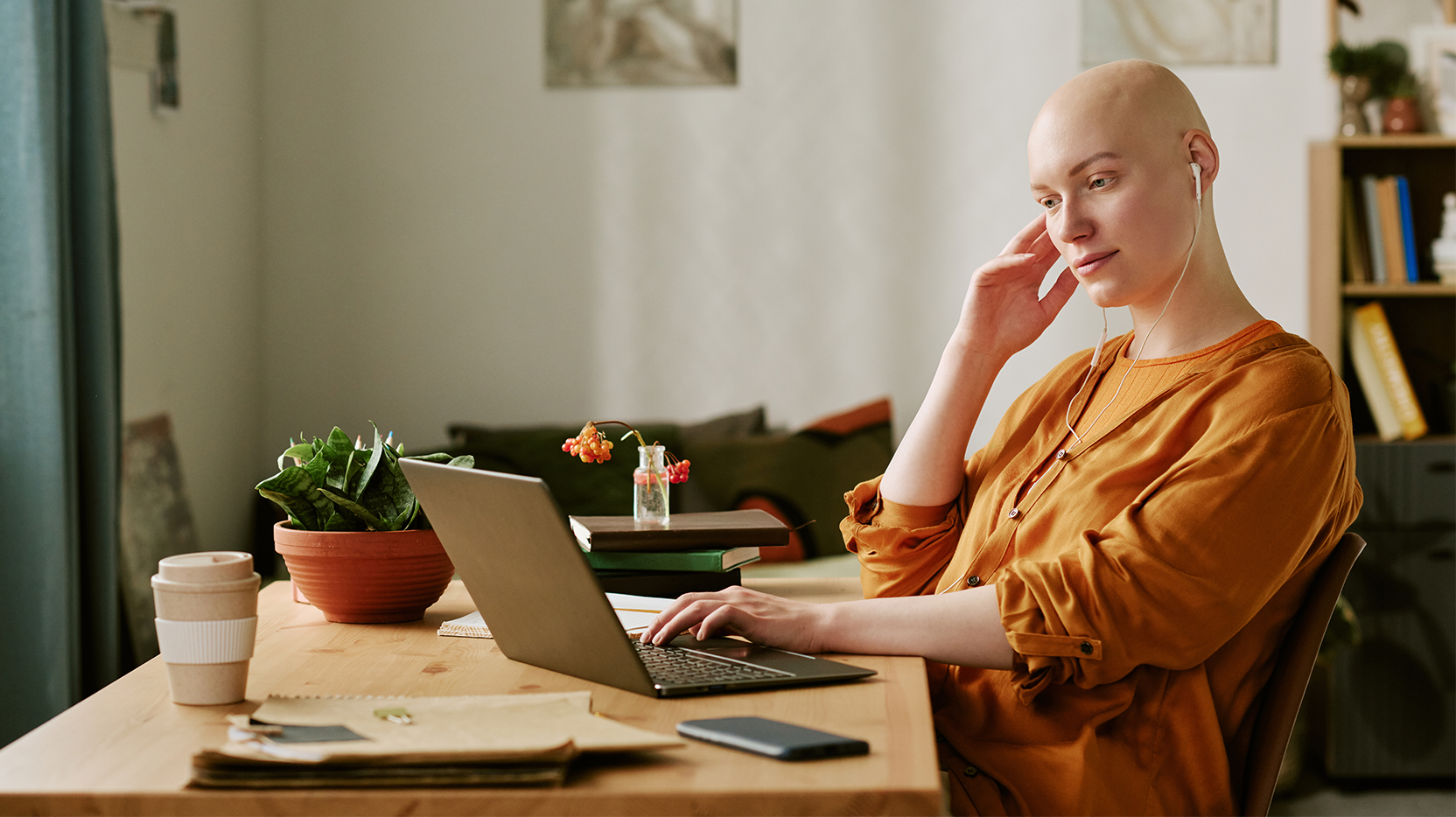 Bald woman working at a laptop in an office