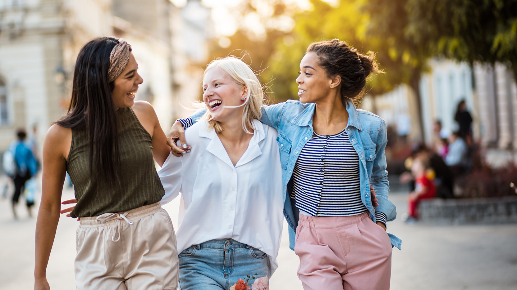 Young women walk down the street together, laughing
