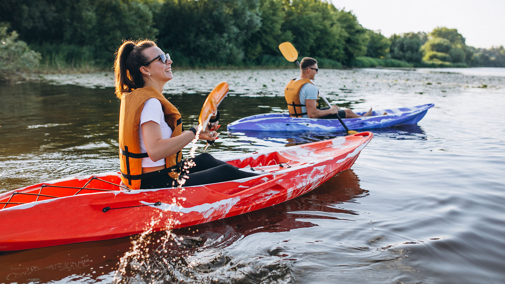 A young couple kayaking on a lake